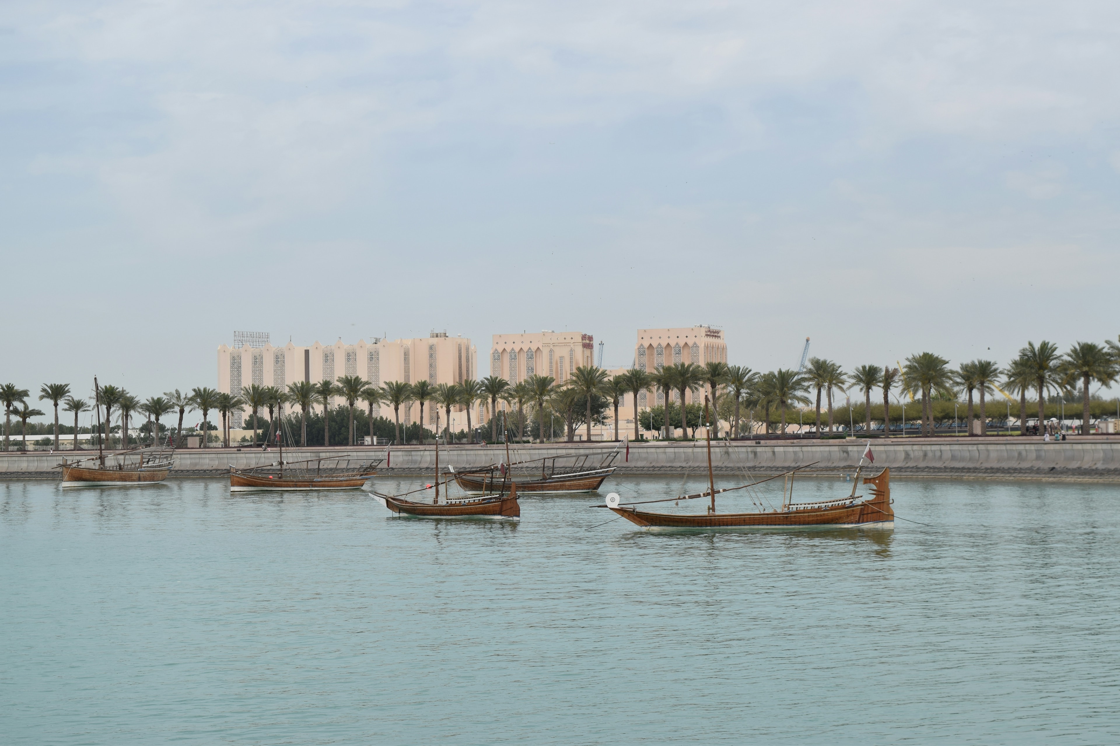 Traditional dhows moored on calm water along the Doha corniche